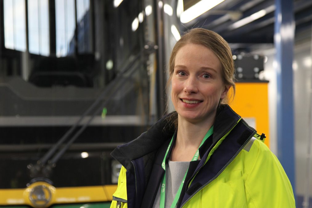Hankepäällikkö Anni Suomalainen seisoo huomiotakki päällä raitiovaunun edessä.