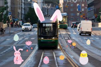 Ratikalla on pupunkorvat, raiteilla piirrettyjä pääsiäiskoristeita.