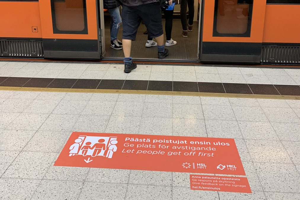 Opaste, jossa lukee "päästä poistujat ensin ulos" metron ovien edessä,