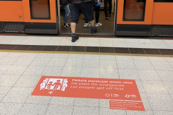 Opaste, jossa lukee "päästä poistujat ensin ulos" metron ovien edessä,