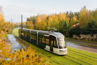 Pikaratikka ajaa syysmaisemassa nurmiradalla.