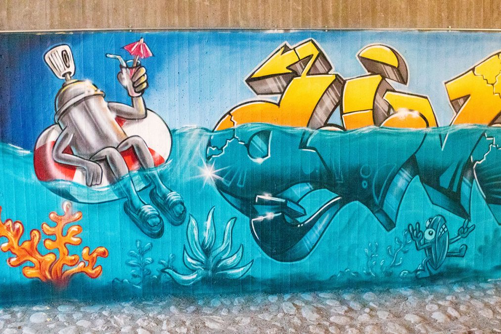 Graffitihahmo drinkillä uimarenkaassa graffititeoksessa raitiolinjan 13 tunnelissa Vallilanlaaksossa.