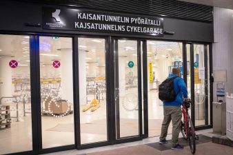 Henkilö taluttaa pyörää Pyörätalliin.
