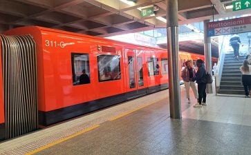 Metrojuna ja ihmisiä Herttoniemen metroasemalla.
