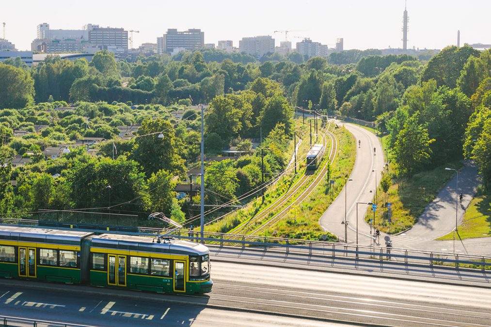 Raitiovaunu Hämeentiellä sillalla ja toinen raitiovaunu Vallilanlaaksossa alhaalla.