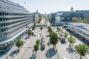 Ilmakuva Mannerheimintieltä Lasipalatsin kohdilta. Ratikka pysäkillä sekä kaksi ratikkaa Forumin risteyksessä.