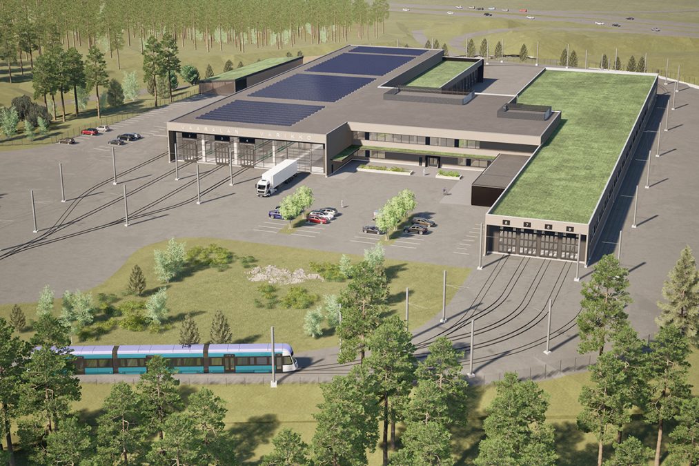 Havainnekuva Vaaralan varikosta. Raitiovaunu menossa halliin, aurinkopaneelit katolla, metsää ympärillä.