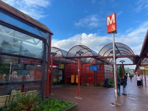 Itäkeskuksen metroaseman sisäänkäynti, jossa punaisia metallisia kattorakenteita.