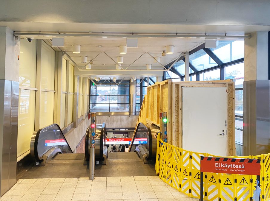 Liukuportaiden yläpää ja vanerinen suojaus.