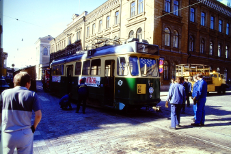 Raitiovaunu keskellä katua ja kikkamiehiä sen ympärillä 1980-luvulla.