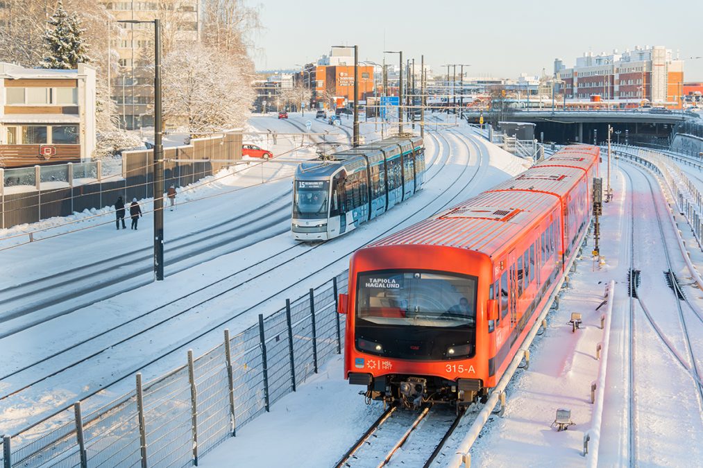 Raitiovaunu ja metro talvisessa maisemassa.