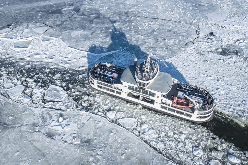 Suomenlinnan lautta ylhäältä päin kuvattuna jäiden keskellä.