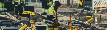 Työntekijöitä huomioasuissa tekee töitä raitiovaunuraiteilla.