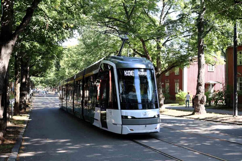 Raitiovaunu koeajoissa Käpylässä, taustalla puita ja puutaloja.